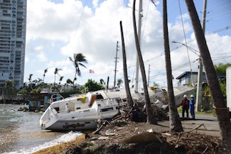Hurricane Maria salvage crews remove wrecked boat from road in Fajardo, Puerto Rico