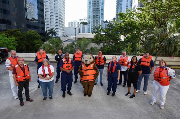 Members of the Coast Guard District Seven wear their life jackets in support of Wear Your Life Jacket To Work day in Miami, Florida, May 21, 2021. This event marks the start of National Safe Boating Week, which helps raise boating safety awareness. (U.S. Coast Guard photo by Petty Officer 3rd Class Jose Hernandez)